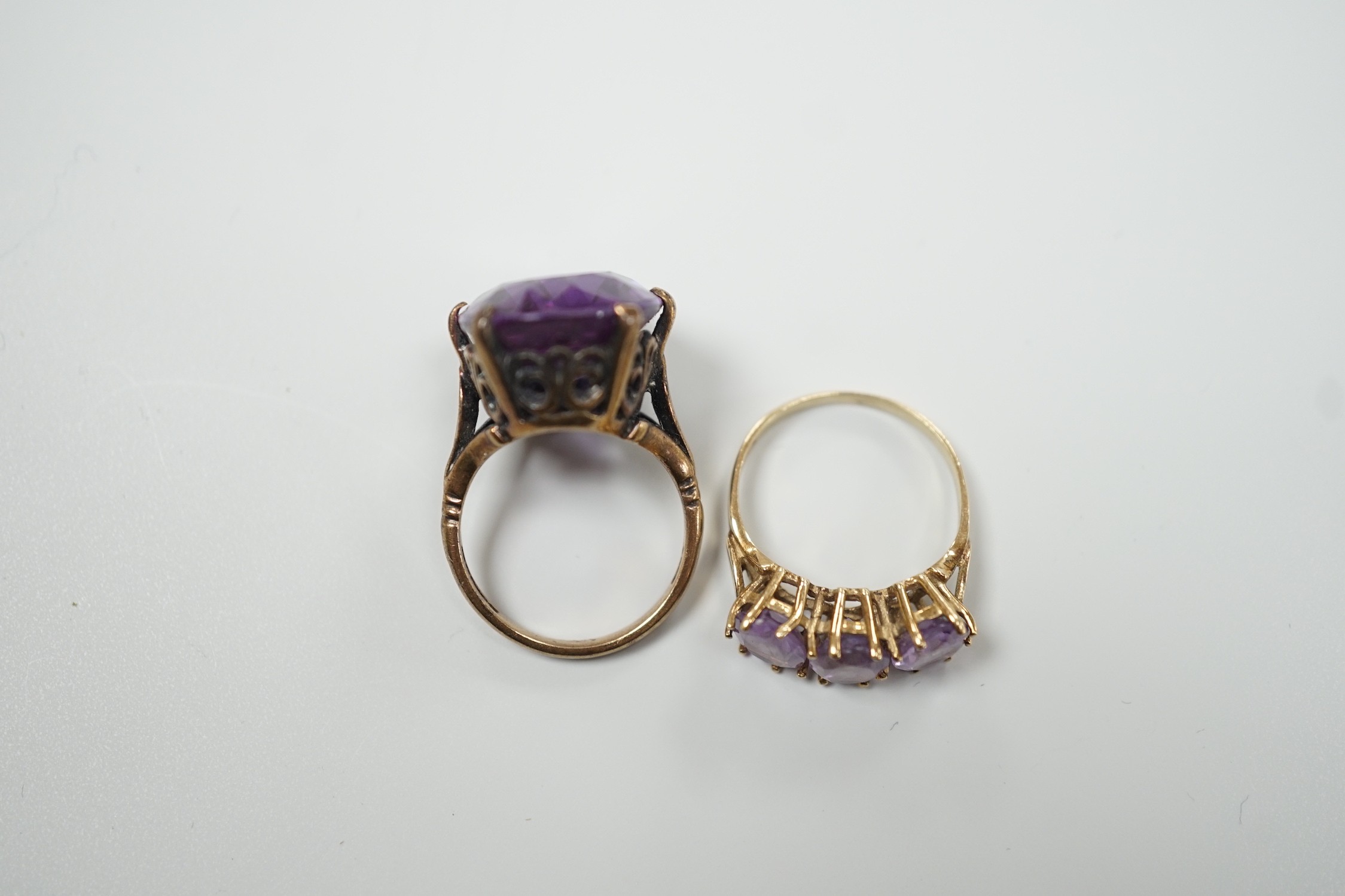 A modern 9ct gold and three stone amethyst set half hoop ring and a 9ct gold and synthetic colour change corundum set dress ring, gross weight 12.4 grams.